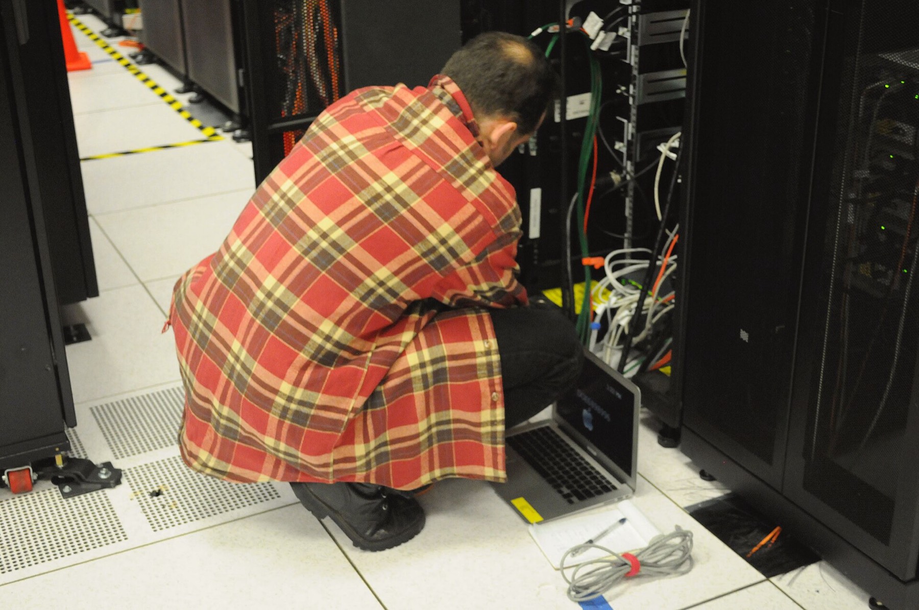 Engineer working at a server rack in a data centre